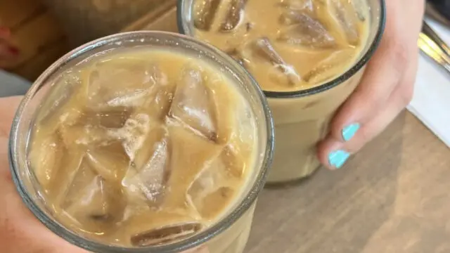 people cheers with iced lattes