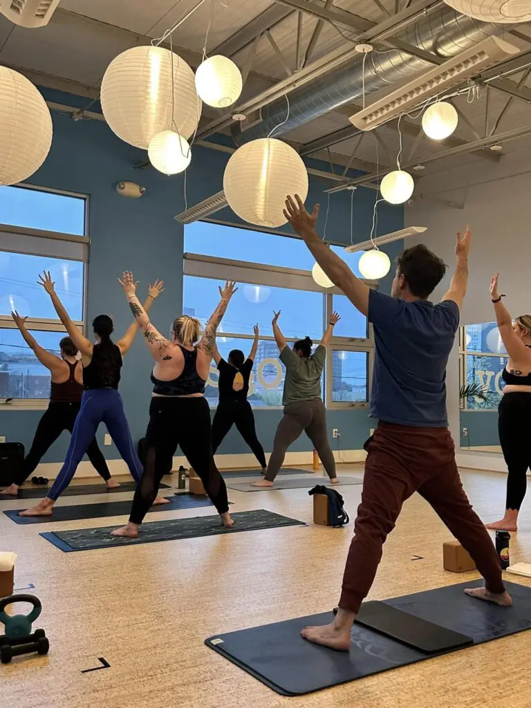 people stretching in yoga pose on mats