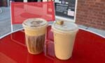 Iced fall lattes sitting on a red table outside