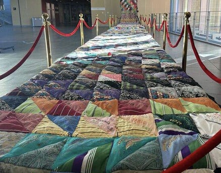 Sidney Brodie’s Durham Homicide and Victims of Violent Death Memorial Quilt in the Durham Arts Council’s lobby, honoring lives lost to community violence.